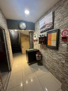un pasillo con un reloj en una pared de ladrillo en Faculte Hotel, en Marsella