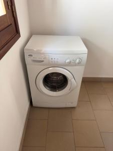 a white washing machine in a corner of a room at Stash House in Cap Skirring