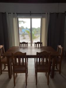 a wooden table and chairs in a room with a window at Stash House in Cap Skirring