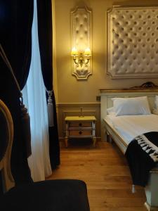 a bedroom with a bed and a lamp and a window at Casa Timpuri Vechi in Sibiu