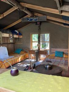 a room with two beds and a table in it at Refugio Casa Piedra in Puerto Ingeniero Ibáñez