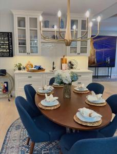 a dining room table with blue chairs and a kitchen at Mt Adams Adventure in Cincinnati