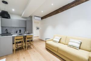 a living room with a couch and a kitchen at History and Design Apartment Facing the Old Port in Genova