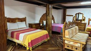 a bedroom with two beds and a chair at Hotel Colonial Taxco in Taxco de Alarcón