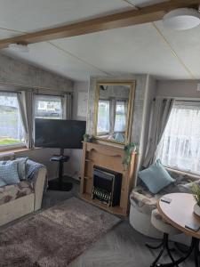 a living room with a fireplace and a tv at E16 Millfields 6 berth caravan MAX 4 ADULTS Bob family's only and lead person must be over 30 in Ingoldmells