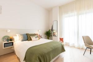 Un dormitorio blanco con una cama grande y una silla. en Vibe Stay Sevilla Residencia de Estudiantes - Adults Only, en Sevilla 16 fotos más