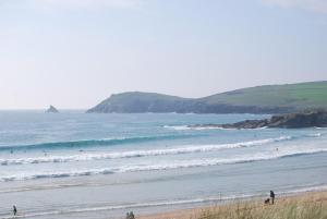 a group of people on a beach near the ocean at Meadow & Tide in Saint Merryn