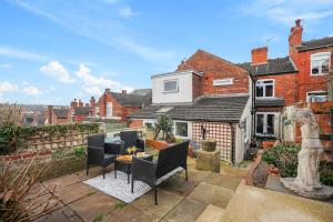 a house with a patio with chairs and a table at Great location in Lincoln beautiful house for families and contractors in Lincoln