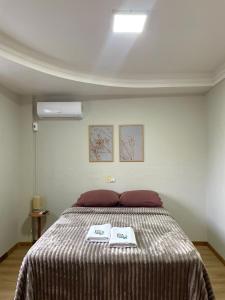 a bedroom with a bed with two certificates on it at Hotelcity in Brusque