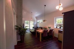 a dining room and living room with a table and a couch at Ferienhaus AlbSommer - FehlaTal in Burladingen