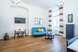 a living room with a blue couch and a table at Royal Road Residence II in Prague