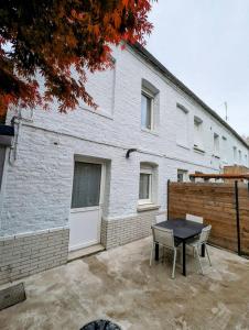 a table and chairs in front of a building at L'apostrophe - Duplex et terrasse in Douai