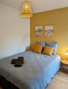 a bedroom with a large bed with pillows on it at L'apostrophe - Duplex et terrasse in Douai