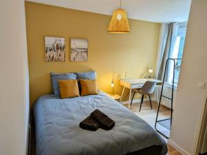 a bedroom with a bed and a table in it at L'apostrophe - Duplex et terrasse in Douai