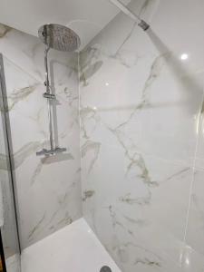 a bathroom with a shower with a white marble wall at L'apostrophe - Duplex et terrasse in Douai +7 photos