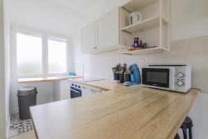a kitchen with a wooden counter top with a microwave at Casetta - Arrière Gare in Arras