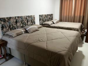 two beds in a hotel room withskirts at Casa Tororão - Arraial d'Ajuda in Porto Seguro +29 photos