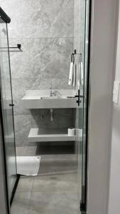 a bathroom with a sink and a glass shower door at Augusto Palace Hotel in Marabá