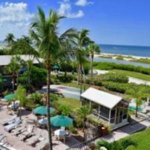 a resort with chairs and umbrellas next to the beach at Caribbean Beach Club in Fort Myers Beach