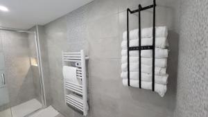 a bathroom with a stack of towels on a wall at Maison Design in Langres