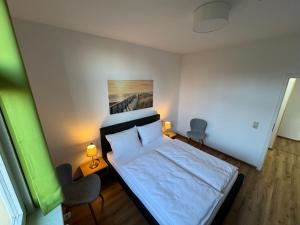 ヴァルタースハウゼンにあるPension Villa am Burgbergの小さなベッドルーム(ベッド1台、椅子2脚付)