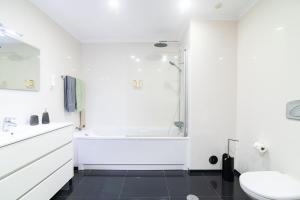 a white bathroom with a shower and a sink at Natural Living Vacations in Furnas +23 photos