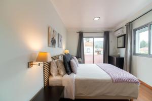 a bedroom with a large bed and a window at Natural Living Vacations in Furnas