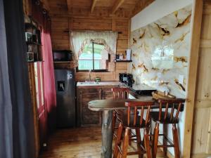 a kitchen with a table and chairs in a room at Cabaña la Corteza in Tanque