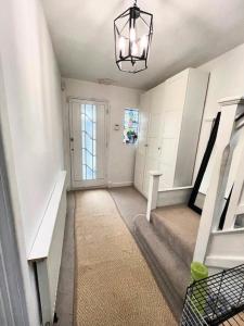 a hallway with a staircase and a chandelier at 4 to 5 Bedroom beautiful holiday home London sleeps 9-central Links in London