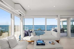 a living room with a white couch and large windows at Waterfront Hot Tub Sauna Private Beach in Wellfleet