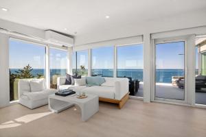 a living room with white furniture and large windows at Waterfront Hot Tub Sauna Private Beach in Wellfleet +41 photos