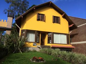 una casa amarilla con ventanas en la parte superior de un patio en El Refugio 700, en Gramado