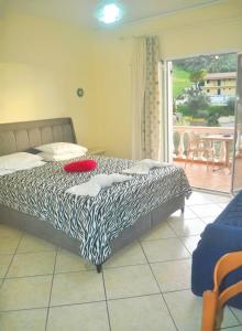 ein Schlafzimmer mit einem Bett mit einer schwarz-weißen Bettdecke in der Unterkunft Holiday House Letta very quiet location Agios Gordios Beach in Agios Gordios