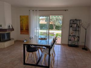 Un comedor con mesa y sillas y una ventana. en Entre plage et vignobles Maison trois chambres, en Saint-Cyr-sur-Mer