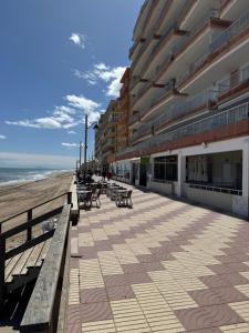 a building on the beach with benches and tables at Brisa de mar in El Perelló