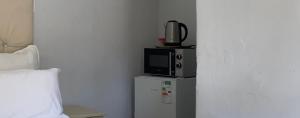 a microwave sitting on top of a refrigerator at Relax Guest House in Ermelo