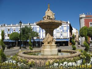 una fuente frente a un edificio blanco en Hostal Valdepeñas by Bossh Hotels en Valdepeñas