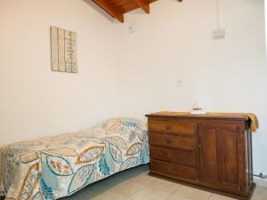 une chambre avec un lit et une commode en bois dans l'établissement Departamento Lionel, à Río Gallegos