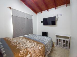 une chambre avec un lit et une télévision à écran plat dans l'établissement Departamento Lionel, à Río Gallegos