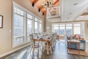 a dining room with a table and chairs and windows at The Tides Inn in Lincoln City