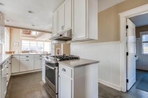 a kitchen with white cabinets and a stove top oven at The Tides Inn in Lincoln City