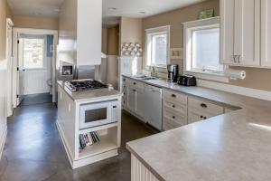 a kitchen with white cabinets and a stove top oven at The Tides Inn in Lincoln City +106 photos