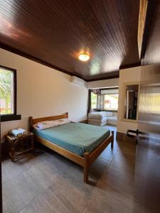 Un dormitorio con una cama con techo de madera. en Canto das Toninhas Guest House, en Ubatuba