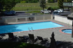 a large blue swimming pool with chairs and a parking lot at Christophe Condo 712 in Ketchum