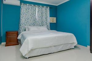 a blue bedroom with a bed and a blue wall at SPECIAL OFFER !! 7 min to Beach - Newly-Renovated Modern Luxury Home in Paradera +31 photos