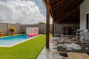 a swimming pool with a pink flamingo in a yard at SPECIAL OFFER !! 7 min to Beach - Newly-Renovated Modern Luxury Home in Paradera