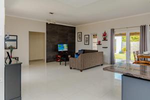 a living room with a couch and a tv at SPECIAL OFFER !! 7 min to Beach - Newly-Renovated Modern Luxury Home in Paradera