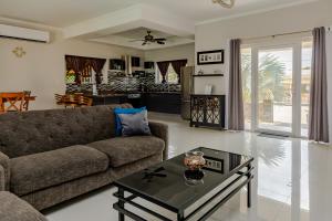 a living room with a couch and a table at SPECIAL OFFER !! 7 min to Beach - Newly-Renovated Modern Luxury Home in Paradera