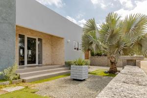 a house with a palm tree in front of it at SPECIAL OFFER !! 7 min to Beach - Newly-Renovated Modern Luxury Home in Paradera