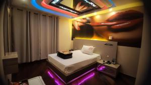 ヴァリーニョスにあるBRUHMOM MOTELの壁に絵画が描かれたベッド付きの部屋